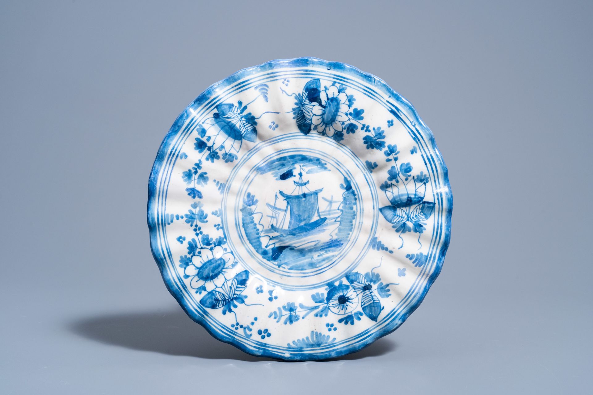 A Dutch Delft blue and white gadrooned dish with a boat and two vases with figures in a garden, 17th - Image 2 of 9