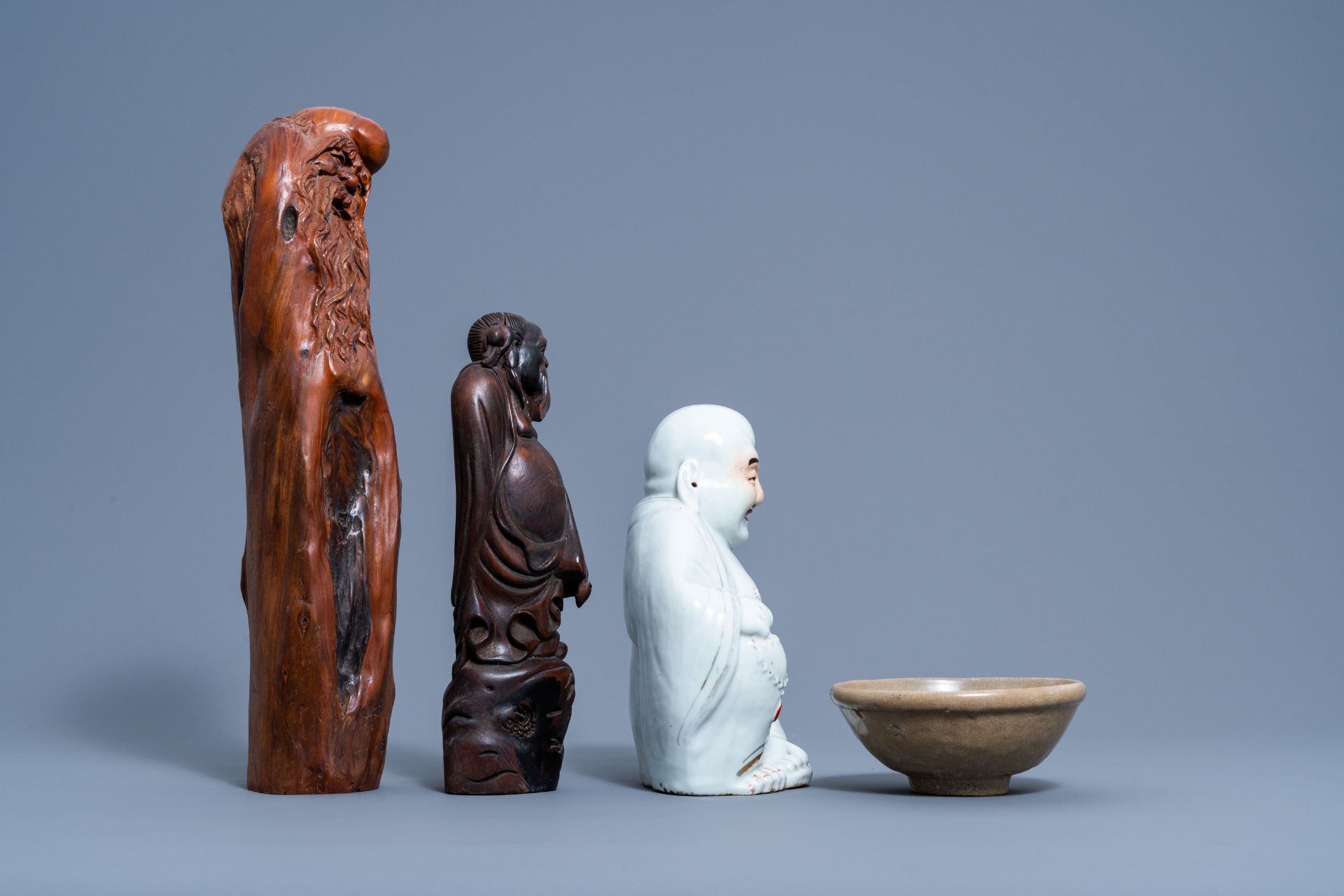 A Chinese white, iron red and gilt porcelain figure of Buddha, two carved wood figures and a celadon - Image 4 of 7