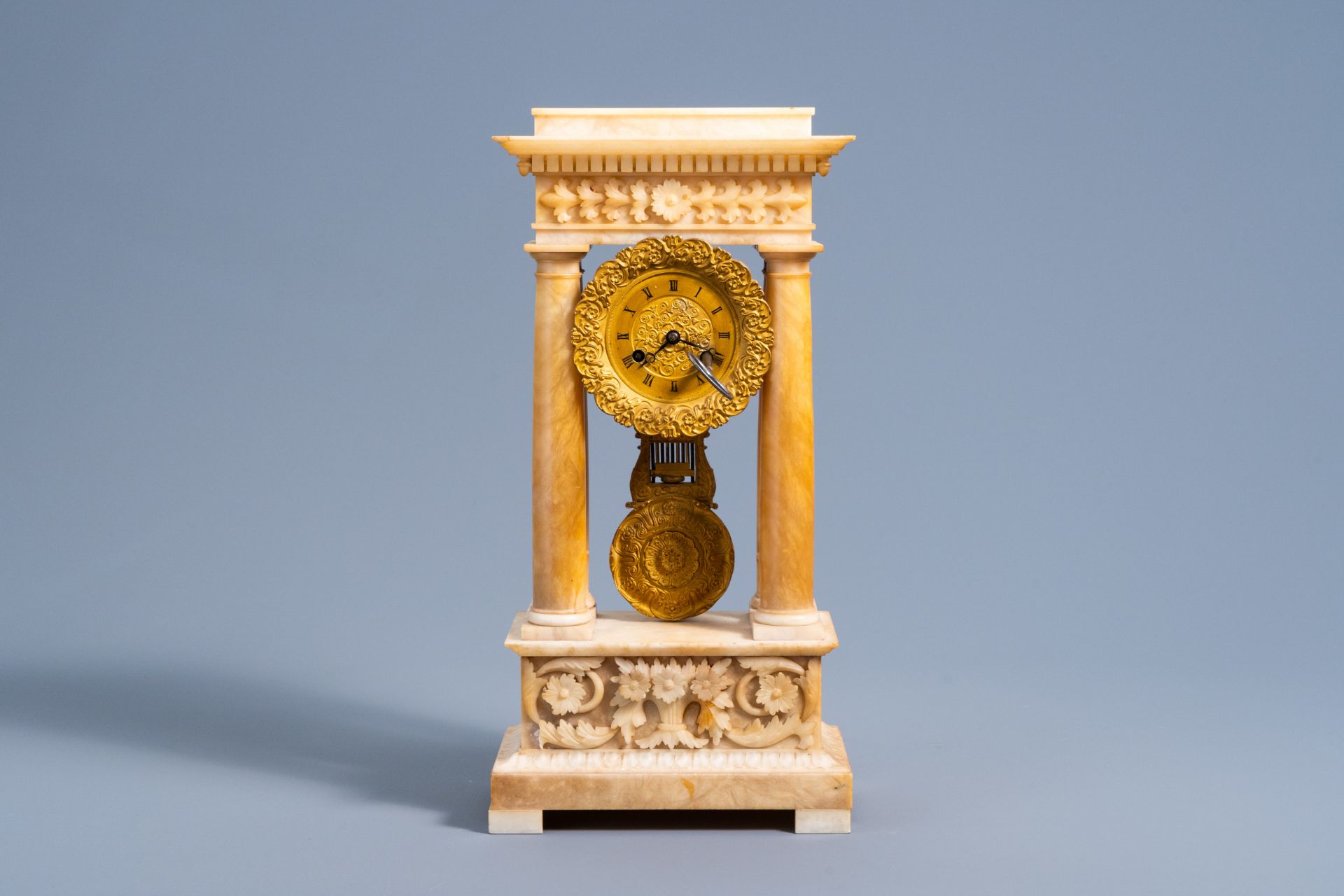 A French bronze and alabaster column mantel clock with floral design, 19th C.