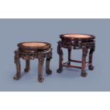 Two Chinese carved wooden stands with marble top, 19th/20th C.