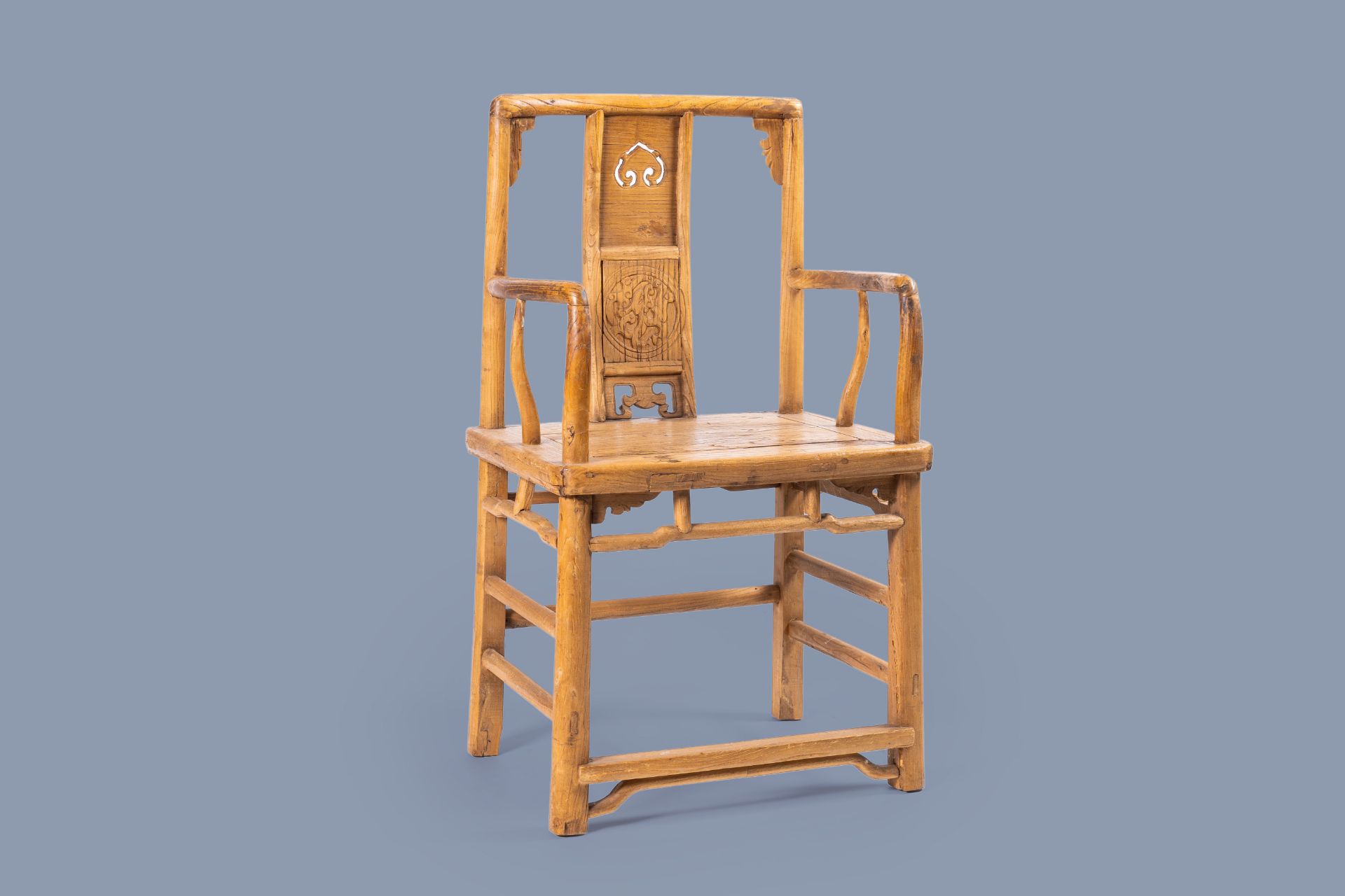 A Chinese elmwood chair with carved and reticulated panels, 19th/20th C.