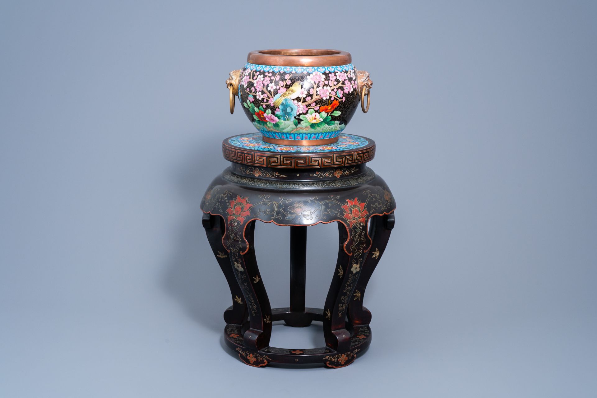A Chinese lacquered wood stand with cloisonnŽ top with a crane and a cloisonnŽ jardinire with birds