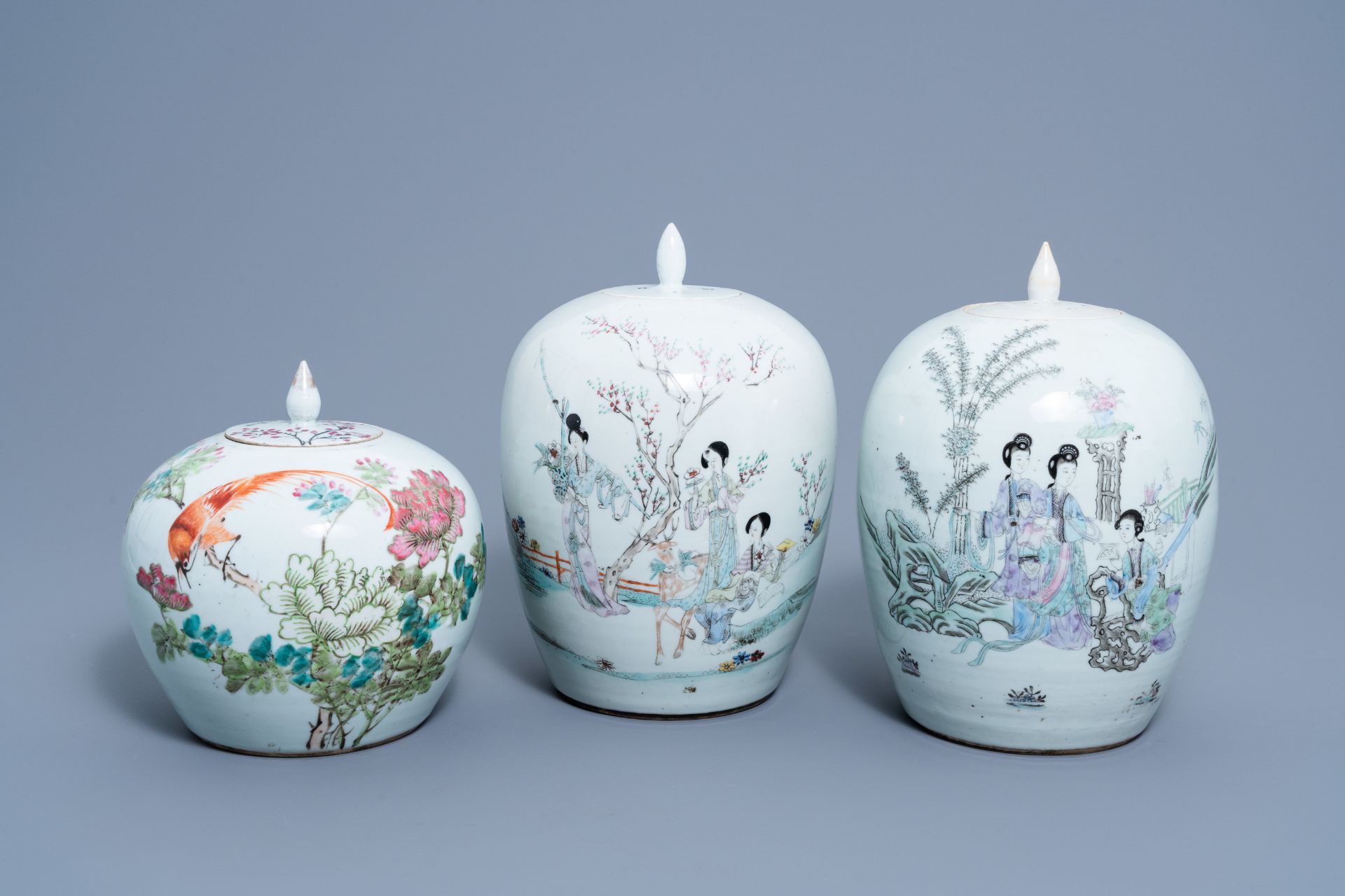 Three Chinese qianjiang cai jars and covers with ladies in a garden and a bird among blossoming bran