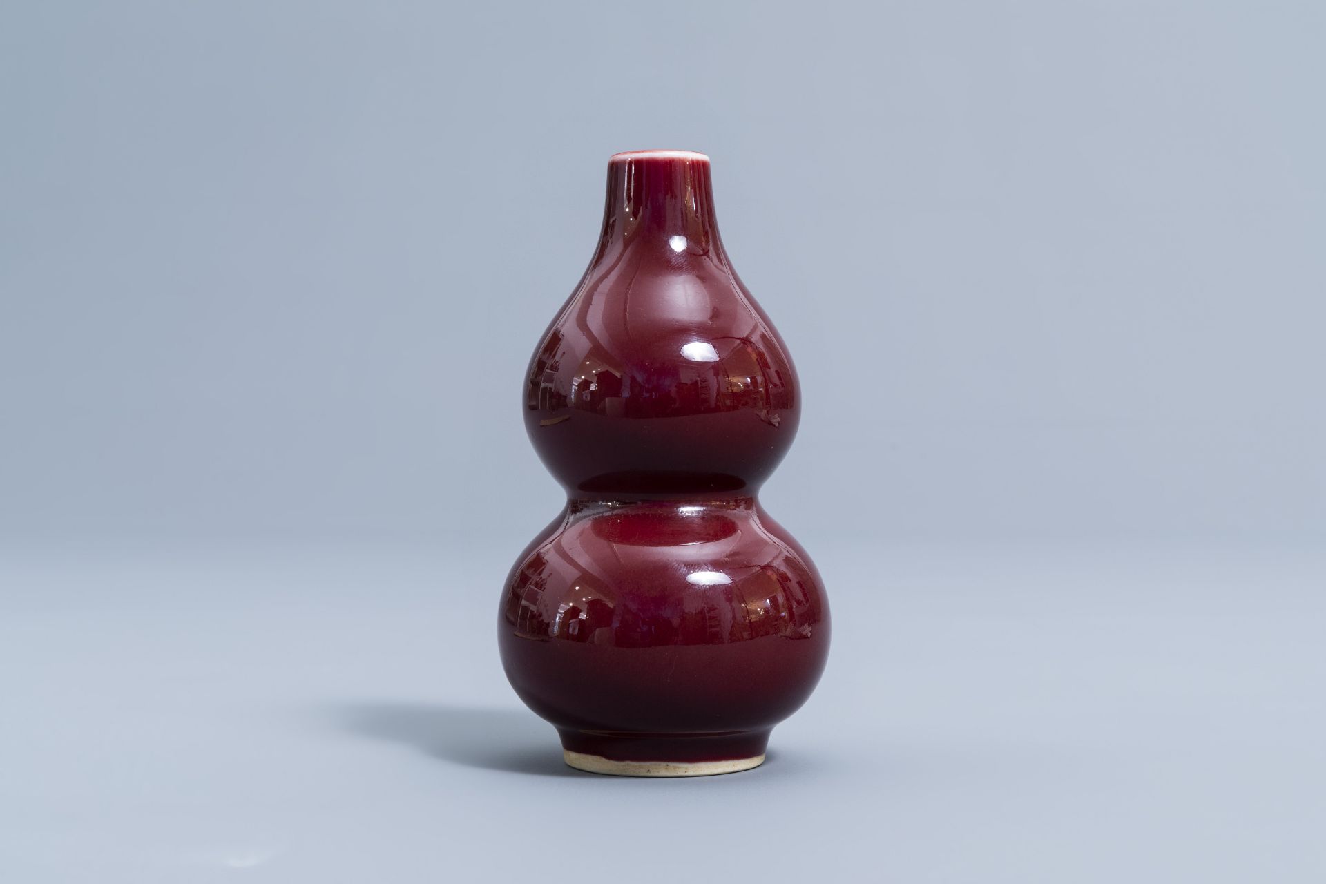 A pair of Chinese red glazed parrots and a monochrome red double gourd vase, 20th C. - Image 9 of 13