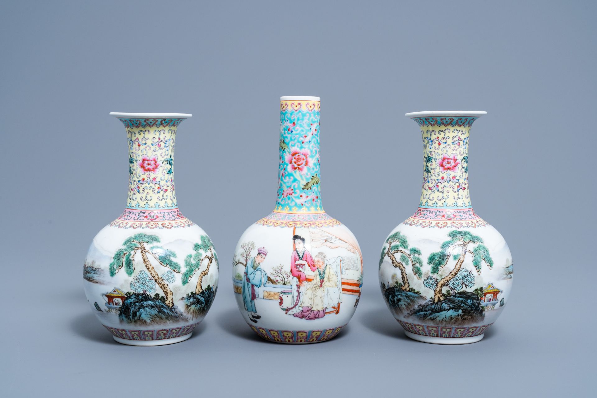 A pair of Chinese bottle shaped famille rose vases with an animated landscape and a vase with figura