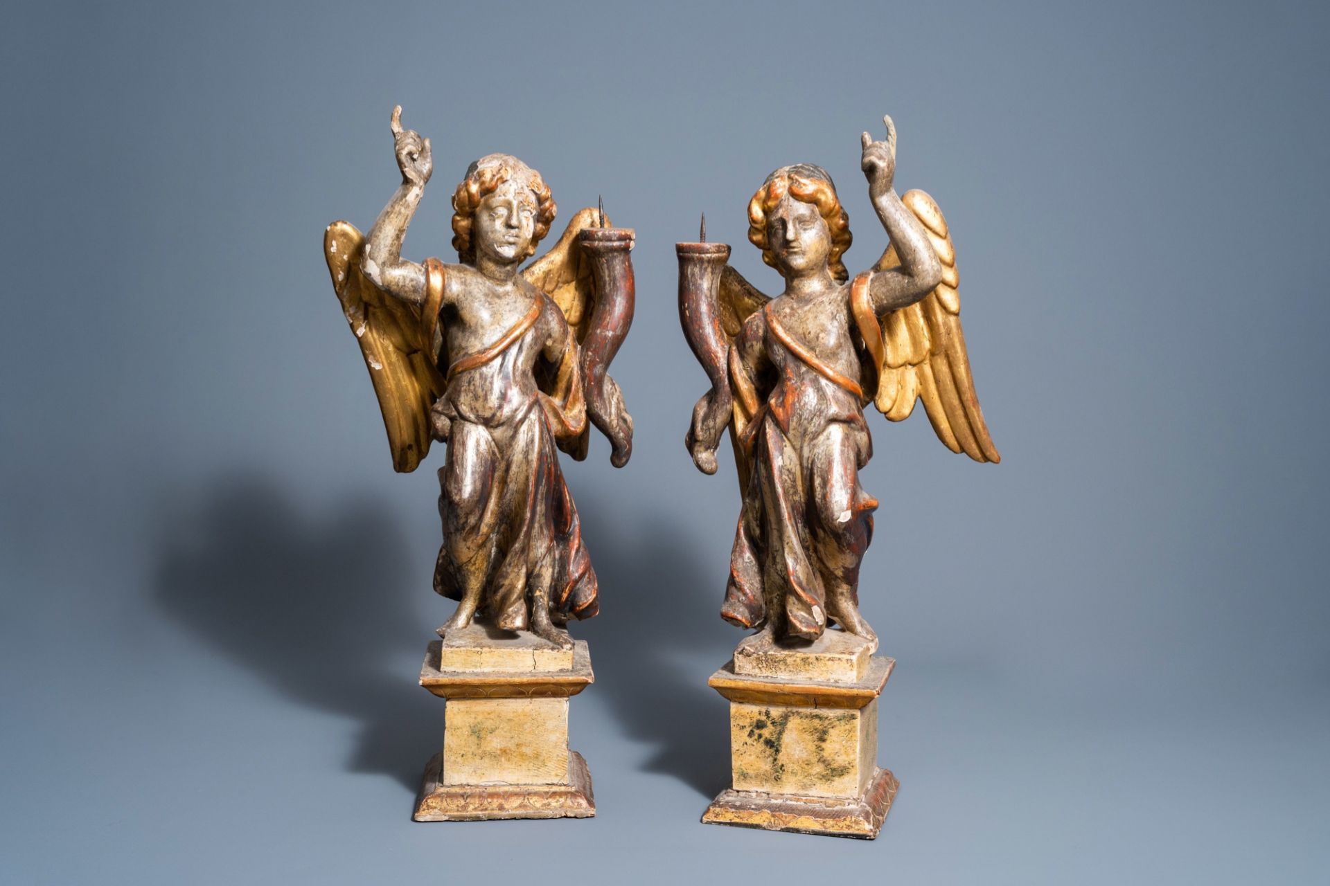 A pair of Italian carved, polychrome painted and gilt wooden angel shaped candlesticks, 18th C.