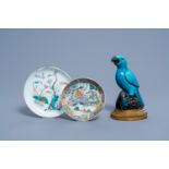 Two Chinese famille rose and verte plates and a turquoise and aubergine glazed parrot, 19th C.