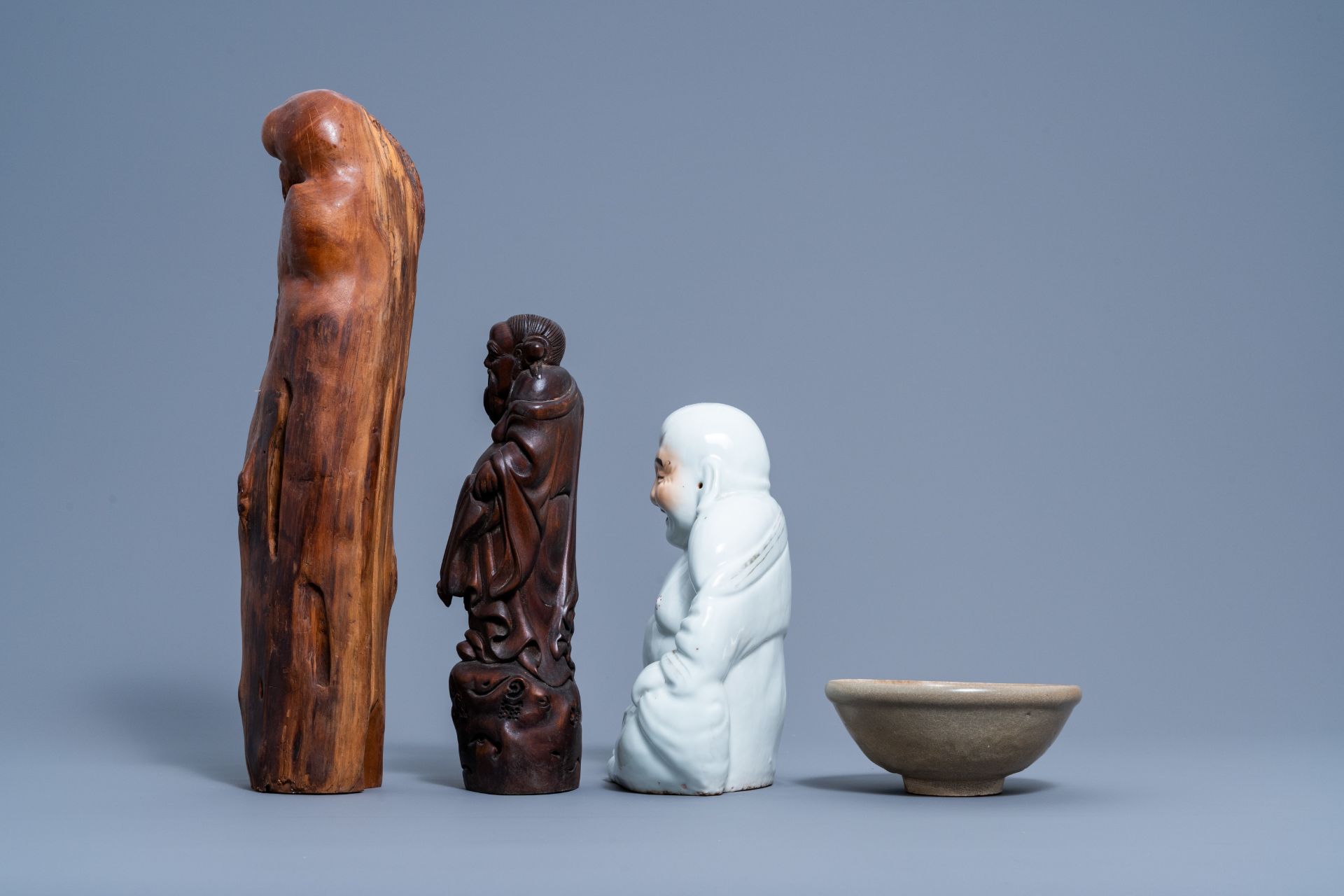 A Chinese white, iron red and gilt porcelain figure of Buddha, two carved wood figures and a celadon - Image 5 of 7