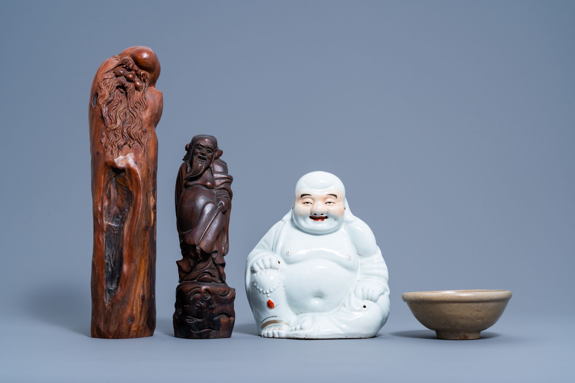 A Chinese white, iron red and gilt porcelain figure of Buddha, two carved wood figures and a celadon - Image 2 of 7