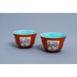 A pair of Chinese famille rose coral red ground bowls with animated scenes, Qianlong mark, 19th/20th