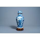 A Chinese blue and white prunus on cracked ice ground vase and cover with floral design on a wooden