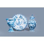 A Dutch Delft blue and white gadrooned dish with a boat and two vases with figures in a garden, 17th