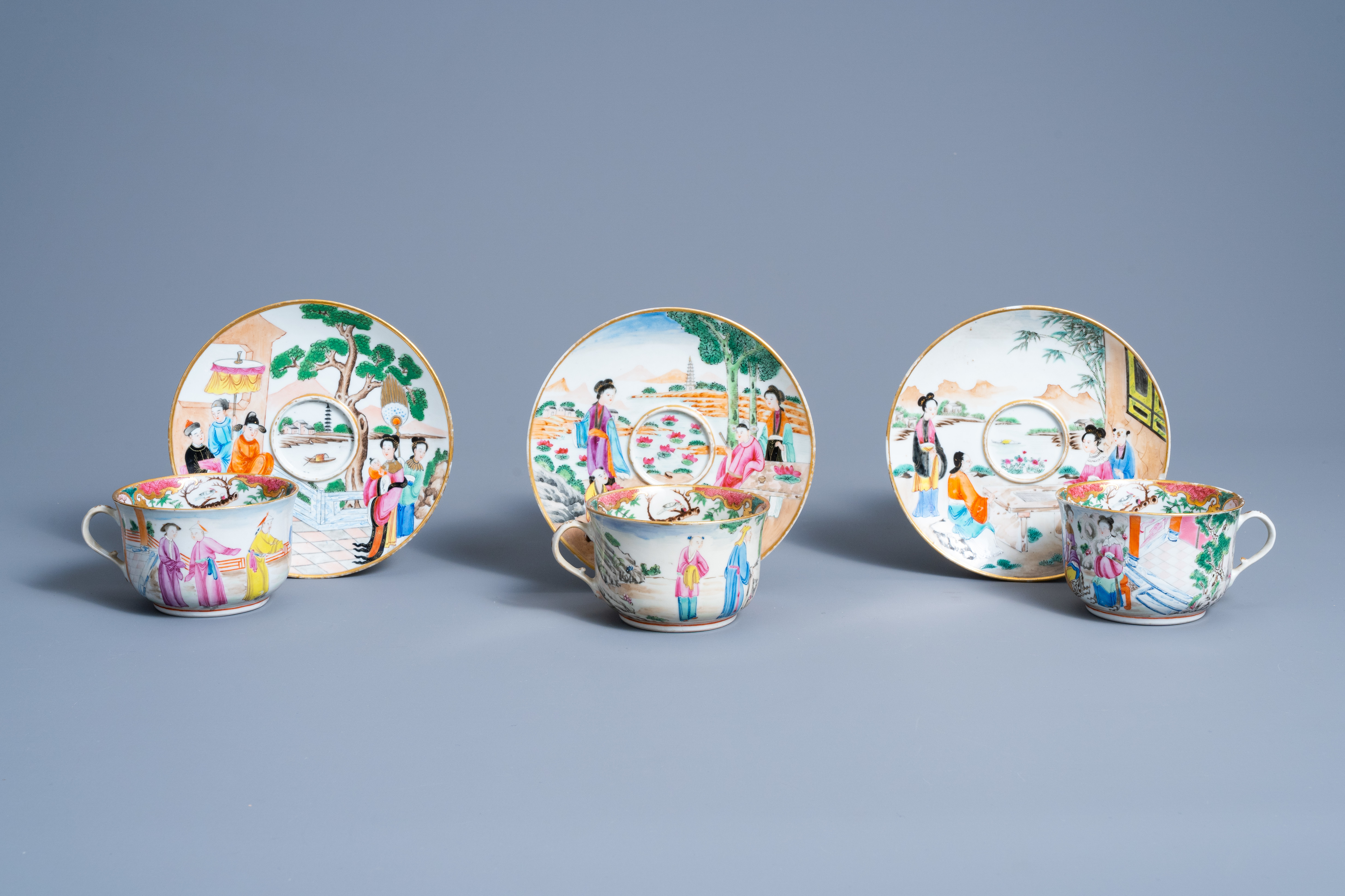 Three Chinese Canton famille rose cups and saucers with figures in a landscape, 19th C.