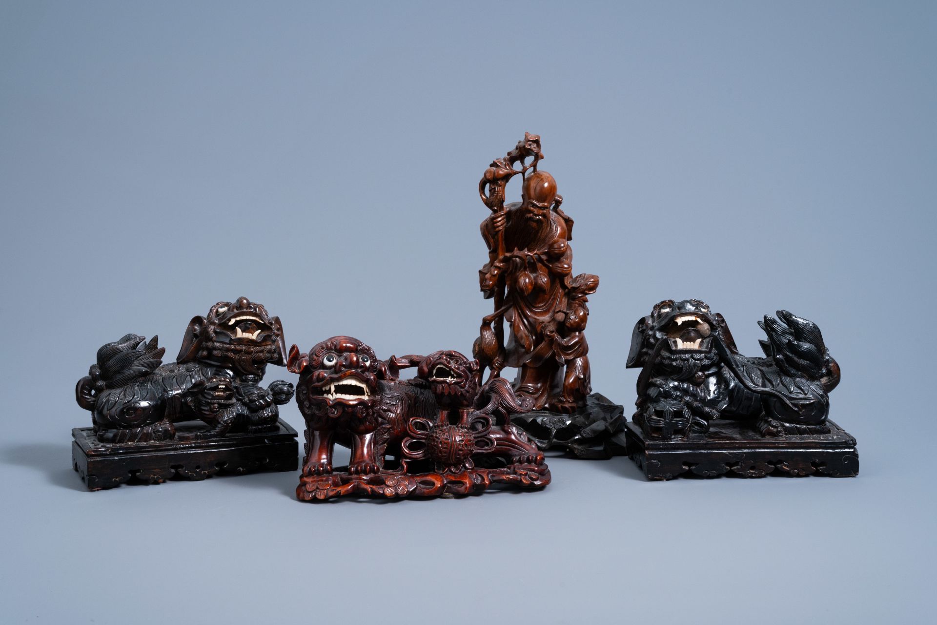 Four Chinese carved wood figures of Shou Lao and Buddhist lions, 19th/20th C.