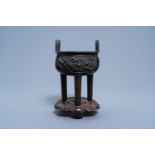 A Chinese bronze tripod censer on wooden stand, Qing