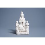A Chinese blanc de Chine group of Guanyin with servants, 20th C.