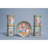 A pair of cylindrical Chinese Canton famille rose vases and a plate with a palace scene, 19th C.