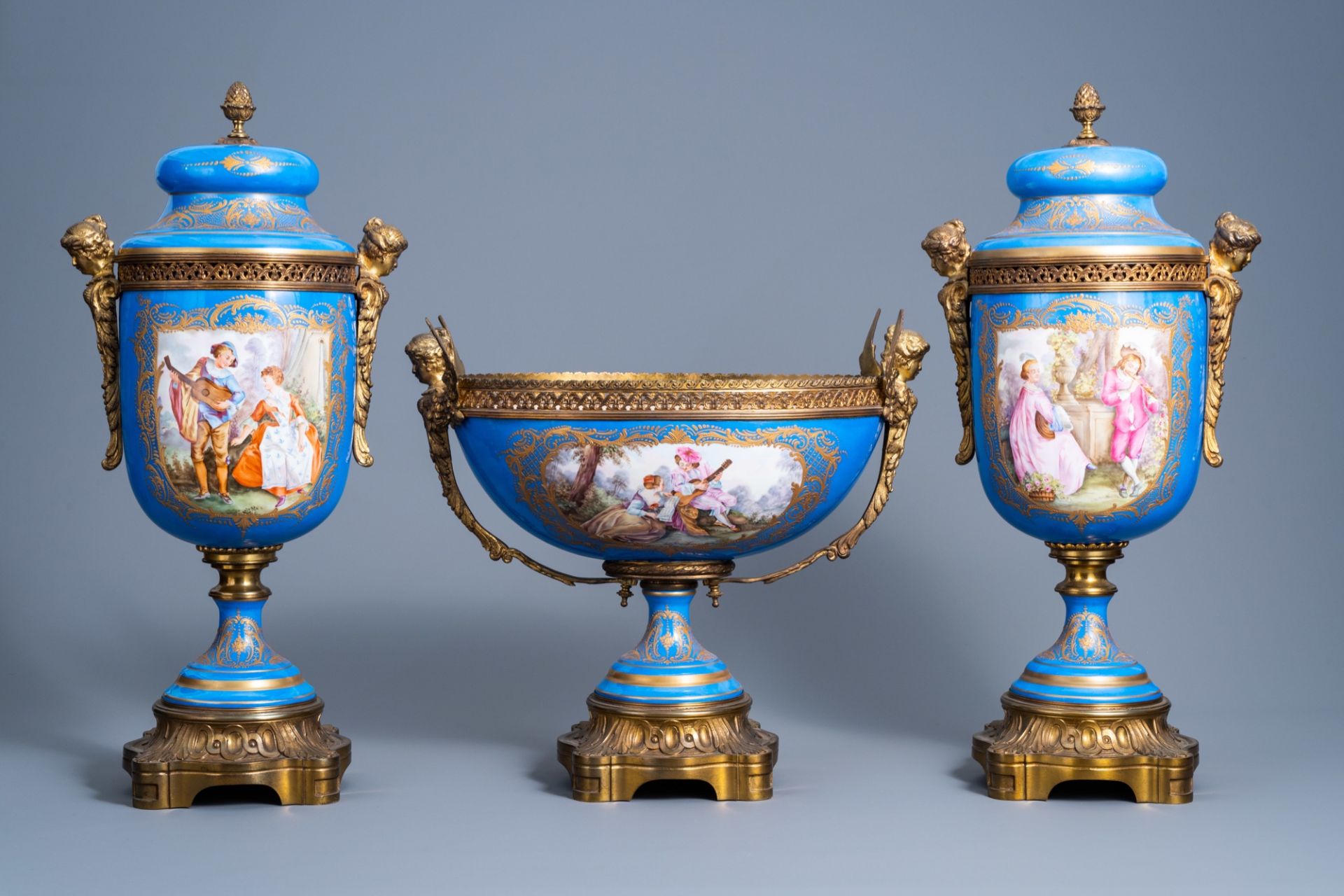 A French gilt bronze mounted 'bleu celeste' ground three-piece garniture with gallant scenes by Lepa