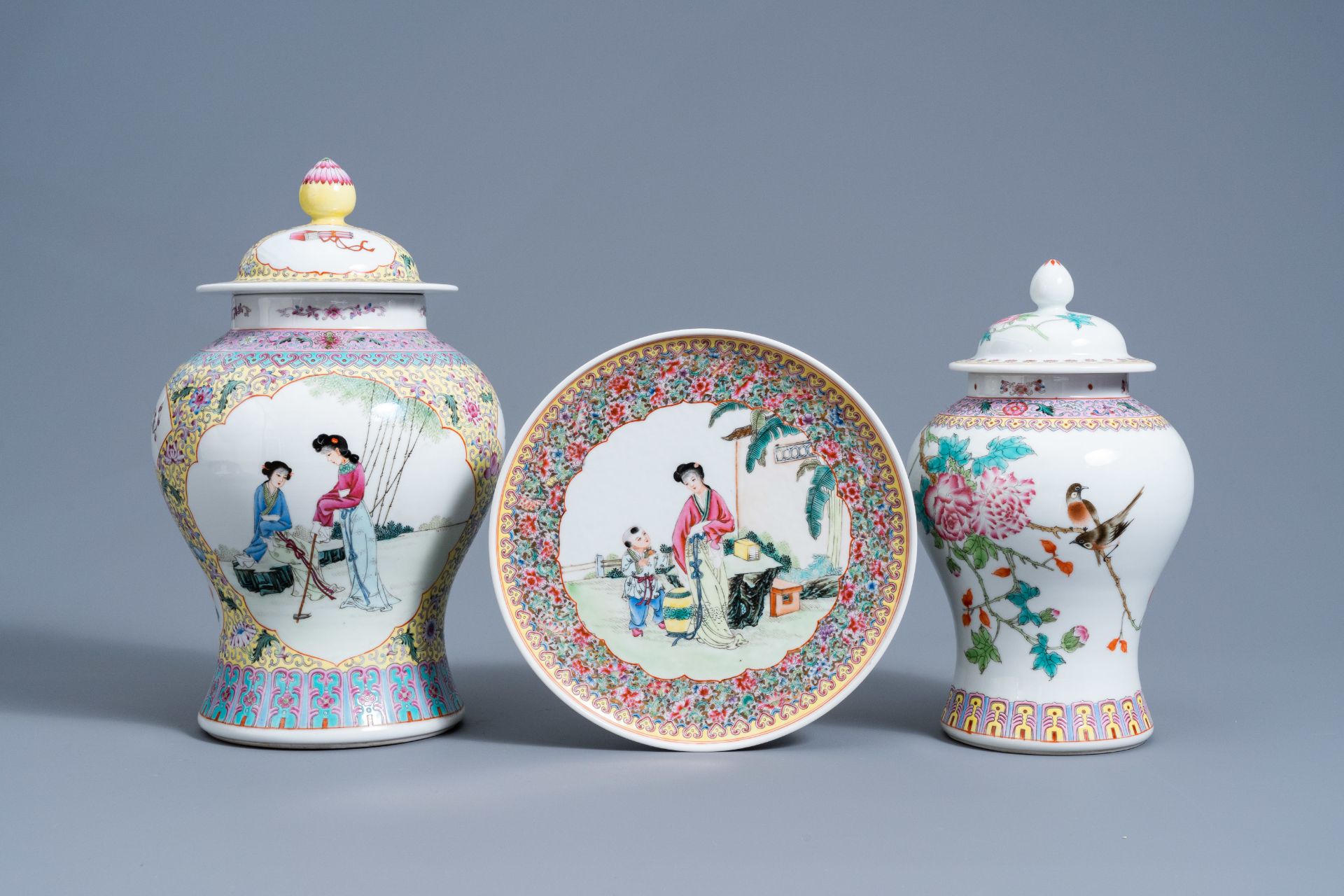 Two Chinese famille rose vases and covers and a plate with figures in a garden, Republic, 20th C.