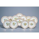 A set of eleven French plates and one oval charger with gilt and polychrome exotic birds design, 19t