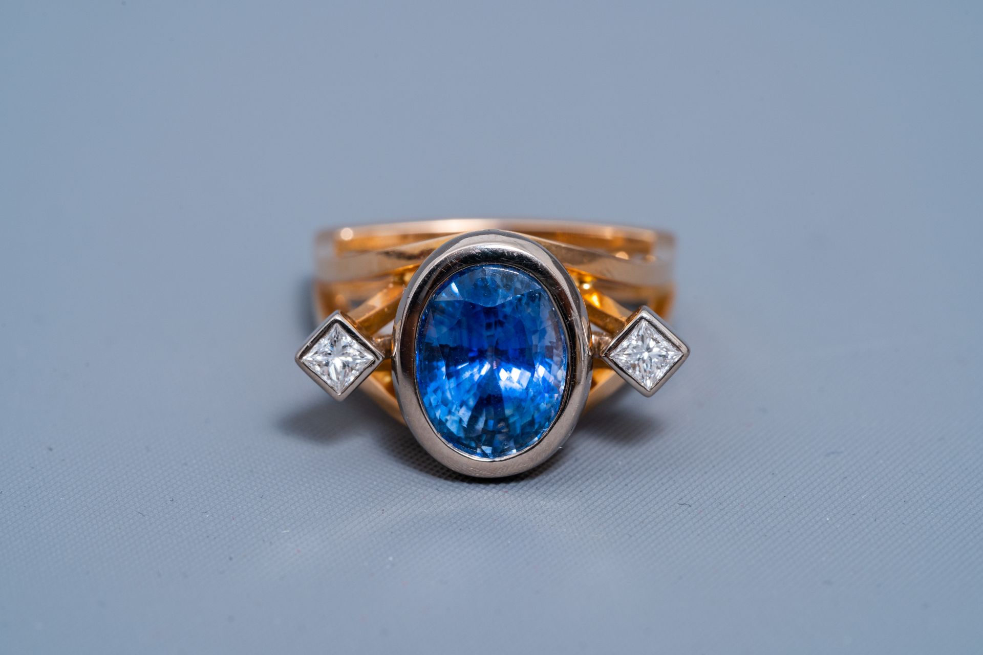 An 18 carat yellow and white gold ring set with a blue sapphire and two diamonds, 20th C. - Image 2 of 7