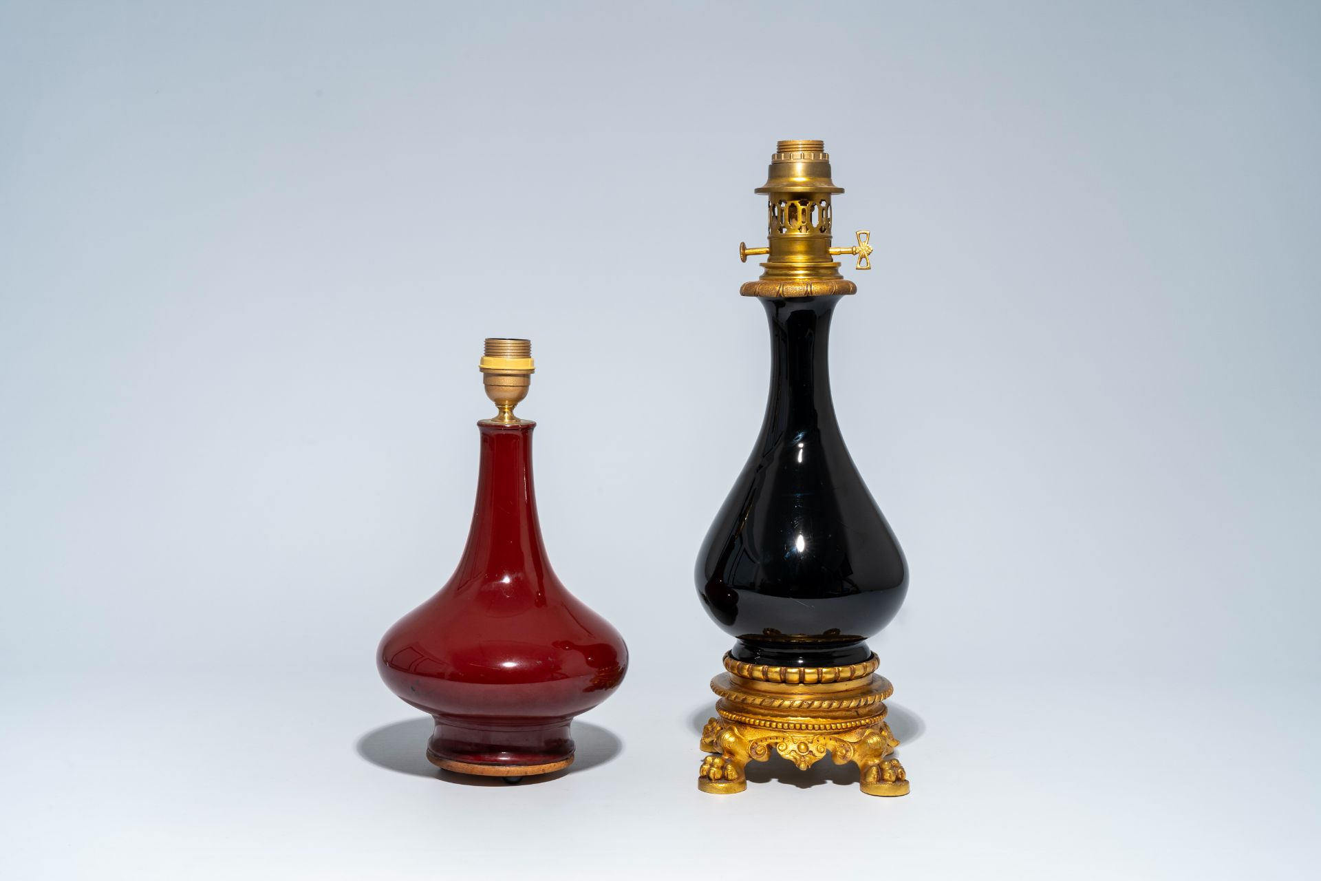 A Chinese monochrome red vase mounted as a lamp and a gilt bronze mounted black glass vase, 19th/20t