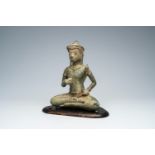 A bronze figure of a seated deity with a shell and a lotus flower in the hands, Thailand or Cambodia