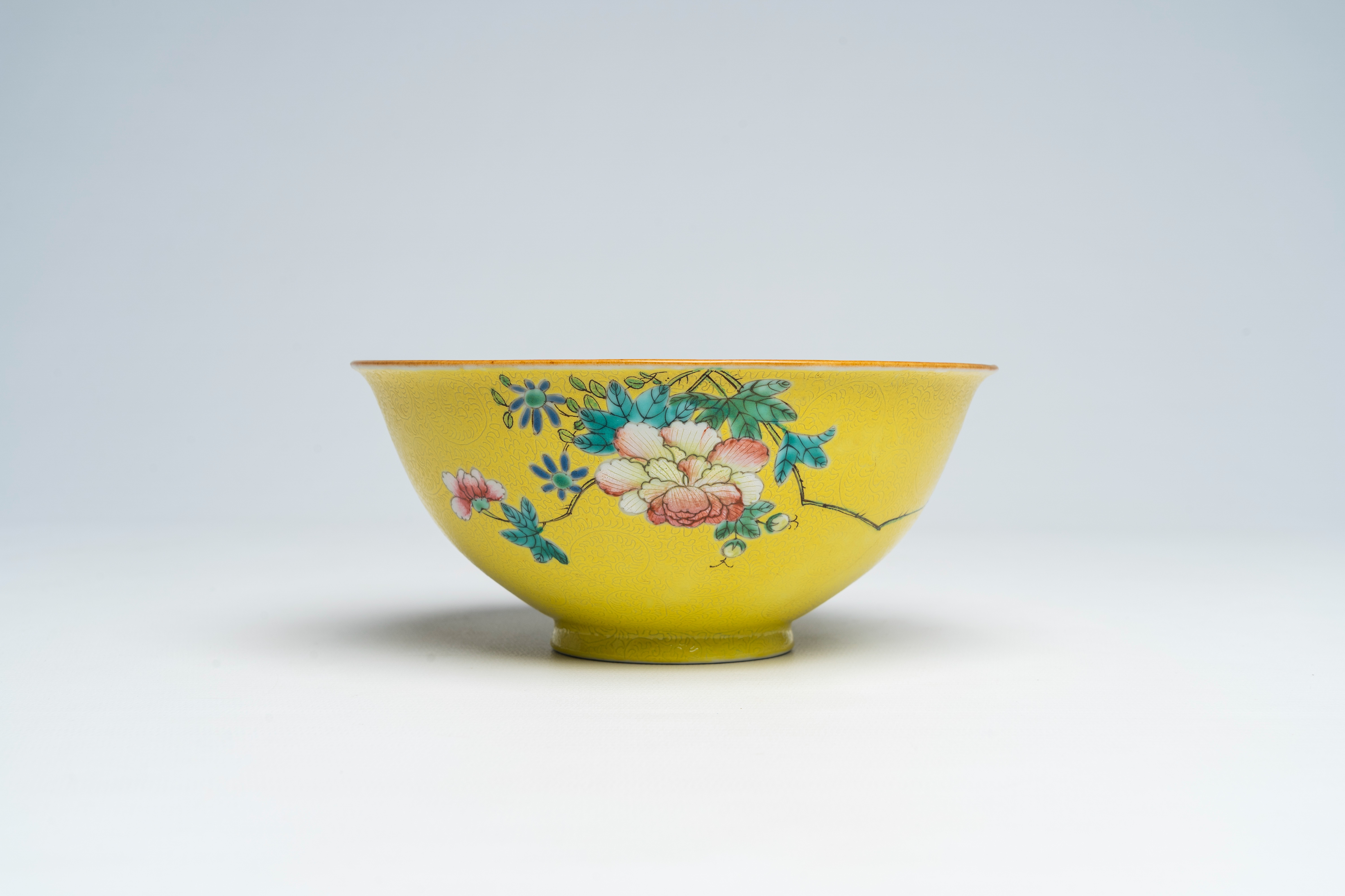 A Chinesefamille rose yellow-ground sgraffito bowl, Qianlong mark, 18th/19th C.