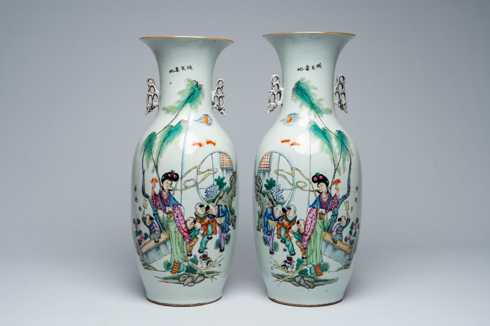 A pair of Chinese famille rose vases with a lady, playing children and a cat in a garden, 19th/20th