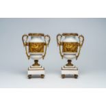 A pair of French gilt mounted white marble vases with relief design of putti, goats and Bacchus them