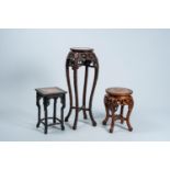 Three Chinese open worked carved wood stands with marble top, 19th/20th C.