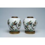 A pair of Chinese bronze and brass mounted famille verte ginger jars with birds among blossoming bra