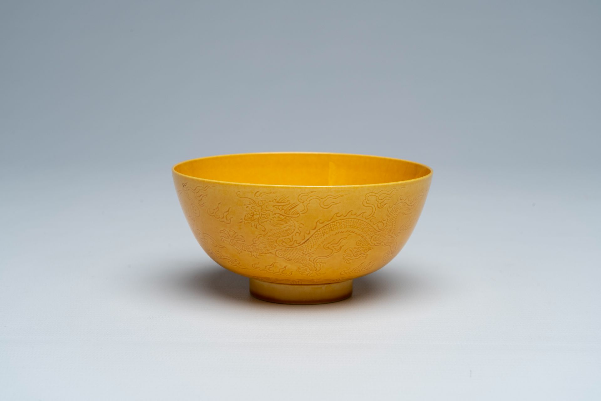 A Chinese monochrome yellow bowl with incised design of dragons and phoenixes, Jiaqing mark, 19th/20