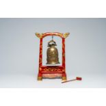 A Chinese gilt and lacquered wood table bell stand and a bronze bell with relief design, 19th/20th C