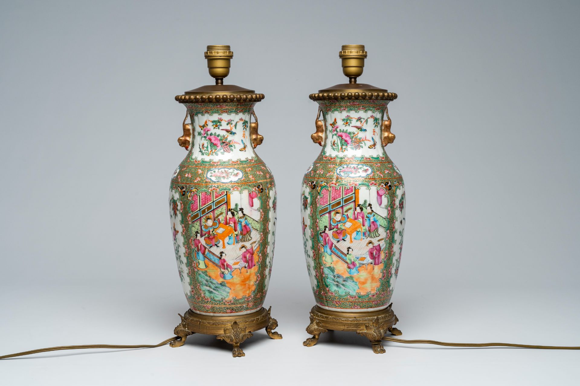 A pair of Chinese Canton famille rose vases with palace scenes mounted as lamps, 19th C.