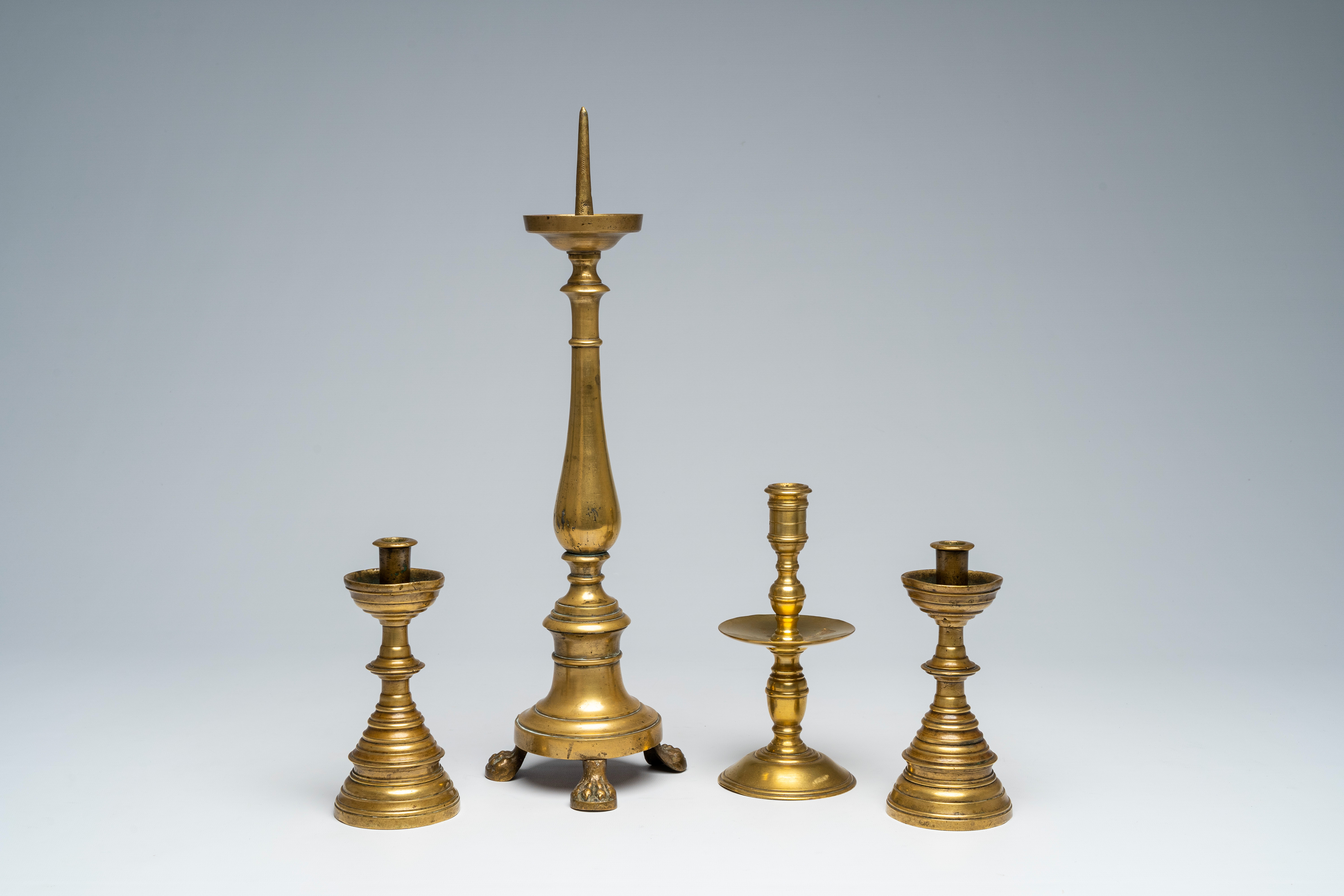 Four various bronze and brass candlesticks, 17th C. and later