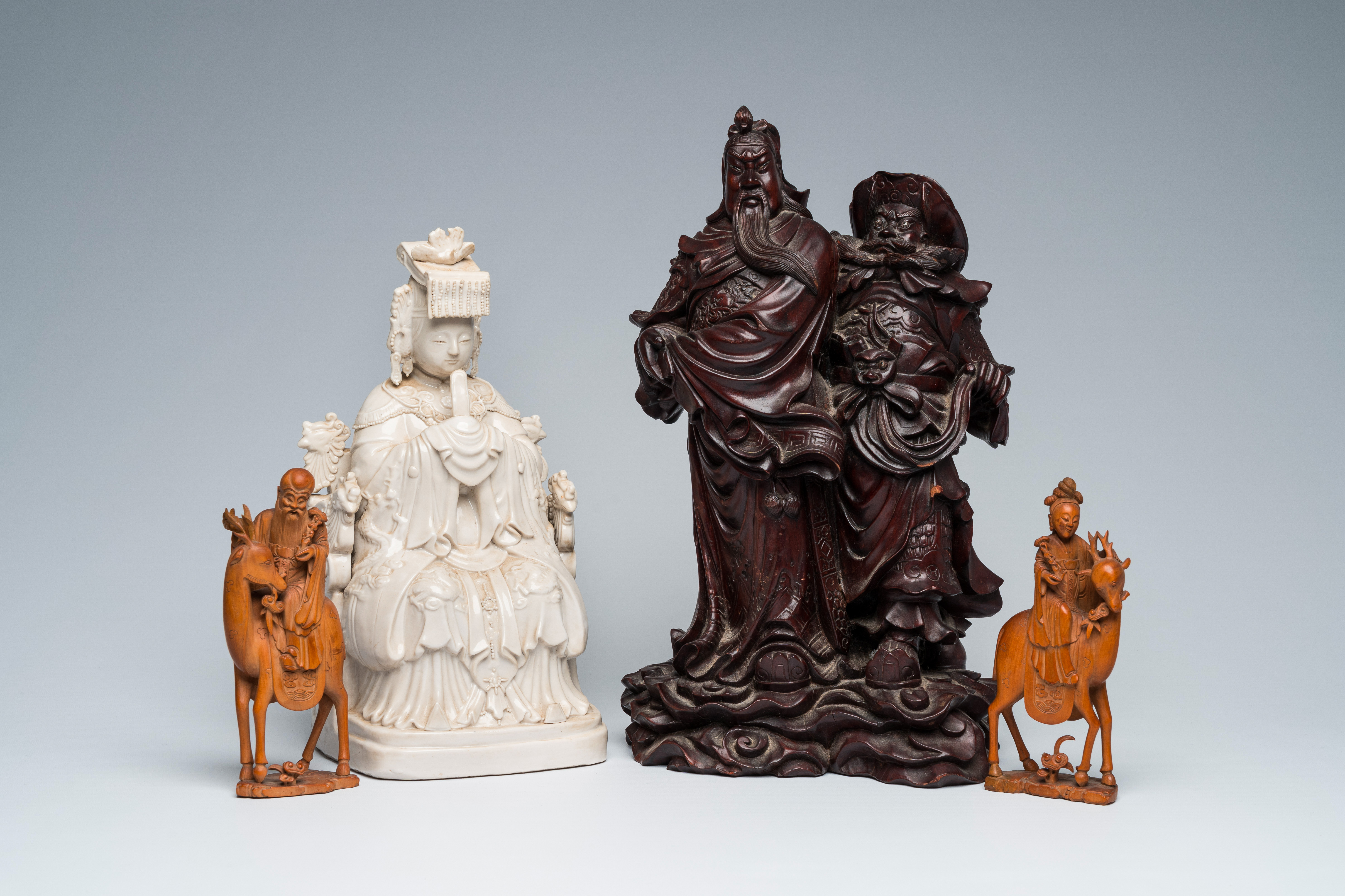 Four various Chinese wood and blanc de Chine figures, 19th/20th C.