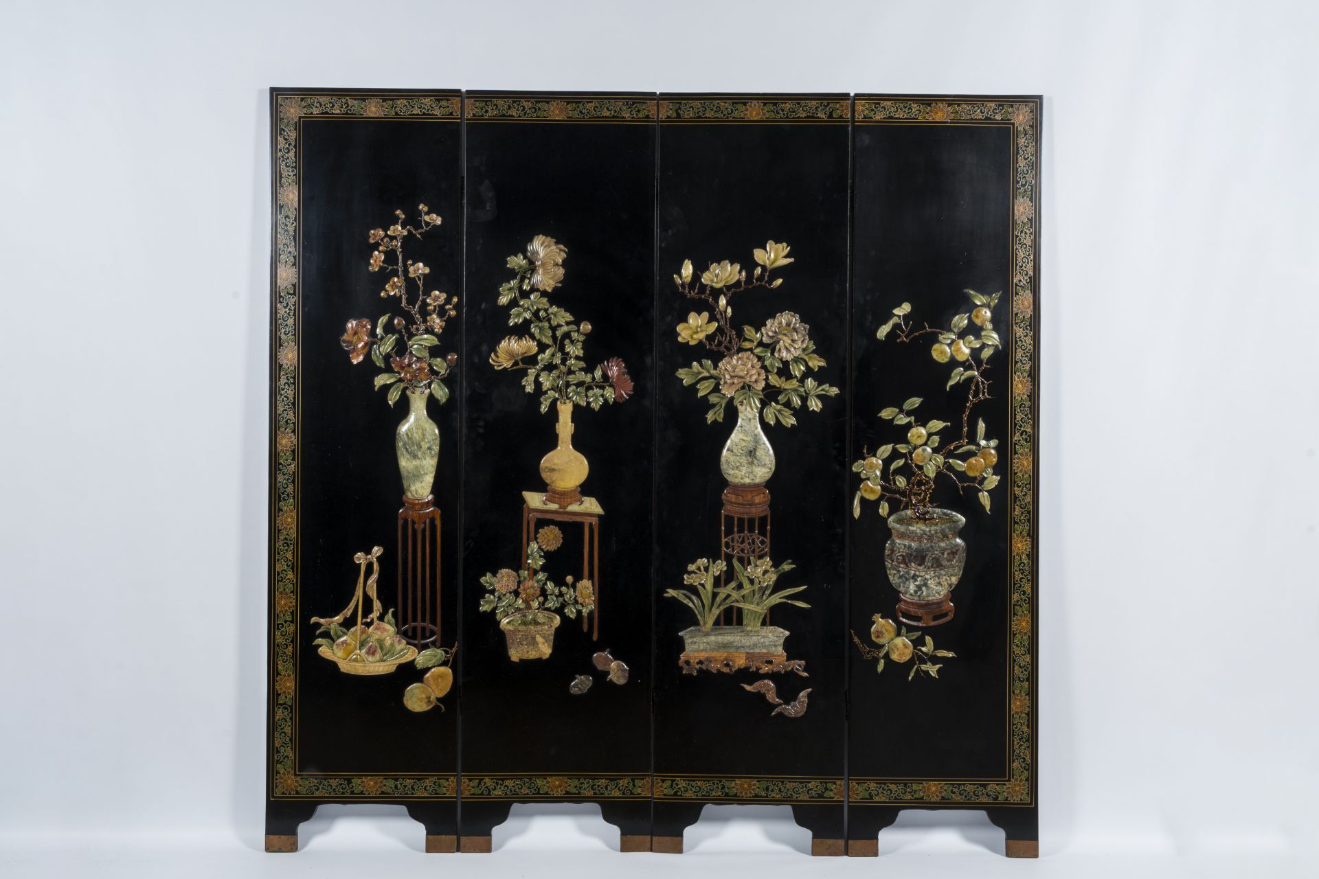 A Chinese four-panel room divider in precious stone-embellished lacquered wood, 20th C.