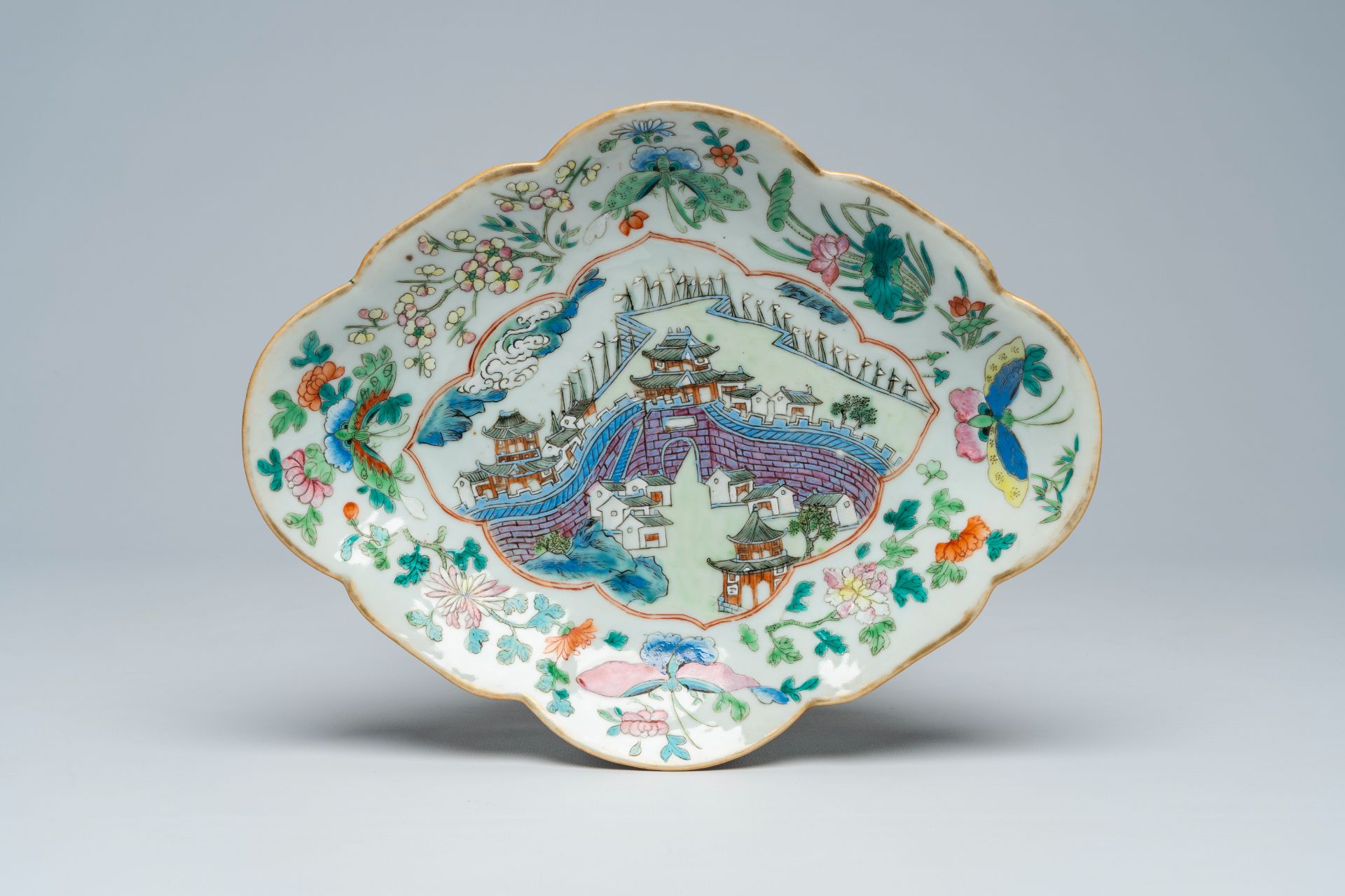 A Chinese famille rose lobed bowl on foot with a landscape with a gate to the Forbidden City, 19th C