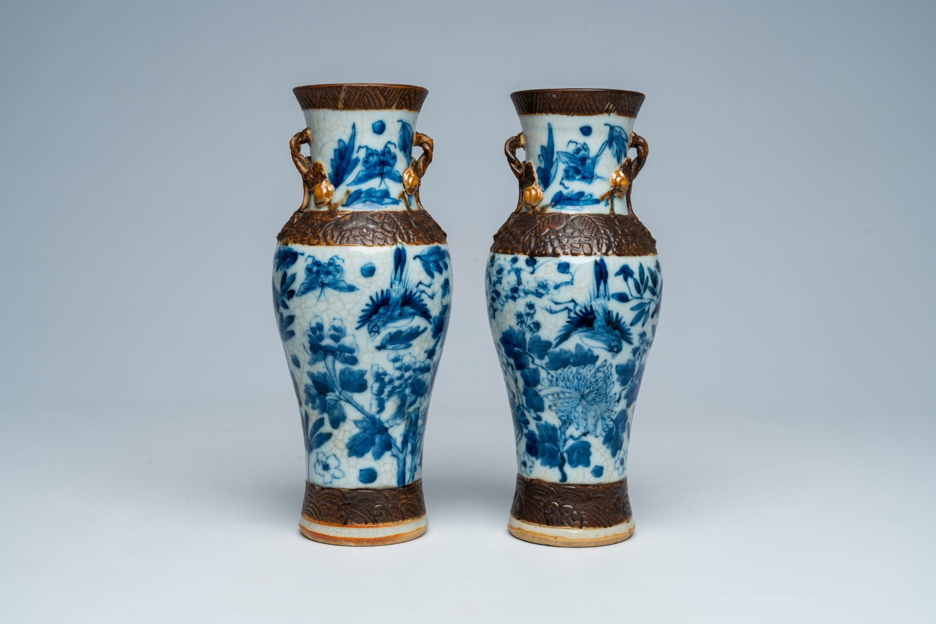 A pair of Chinese Nanking crackle glazed blue and white vases with birds and butterflies among bloss