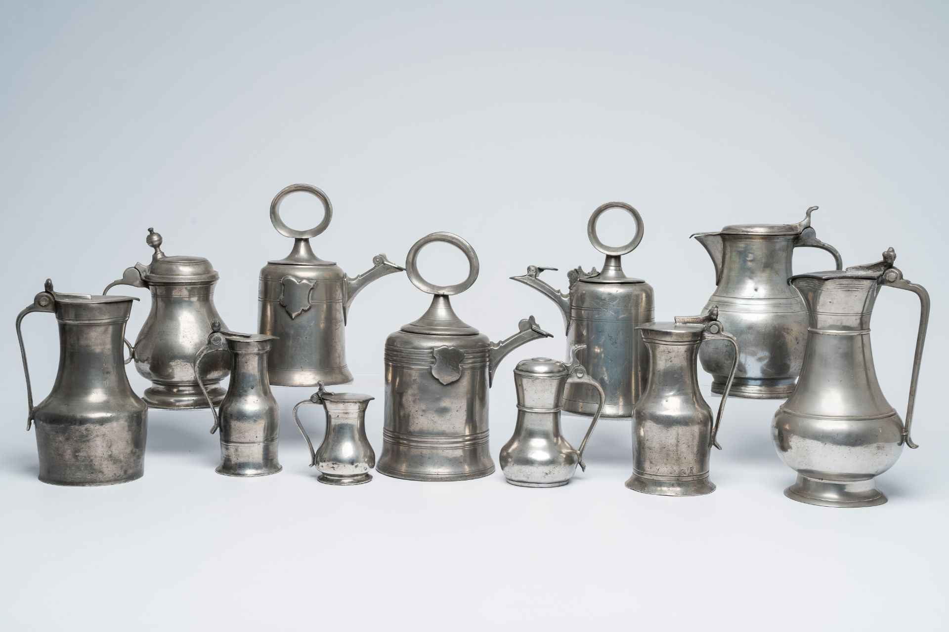 A varied collection of pewter jugs and flagons, a.o. acorn jugs and Swiss Glocken flagons, various o