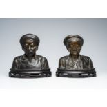 A pair of Vietnamese patinated bronze busts of elders on a wood base, 20th C.