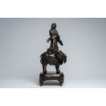 A Japanese bronze Kannon carried by an elephant on a base with engraved floral design, Meiji, 19th C