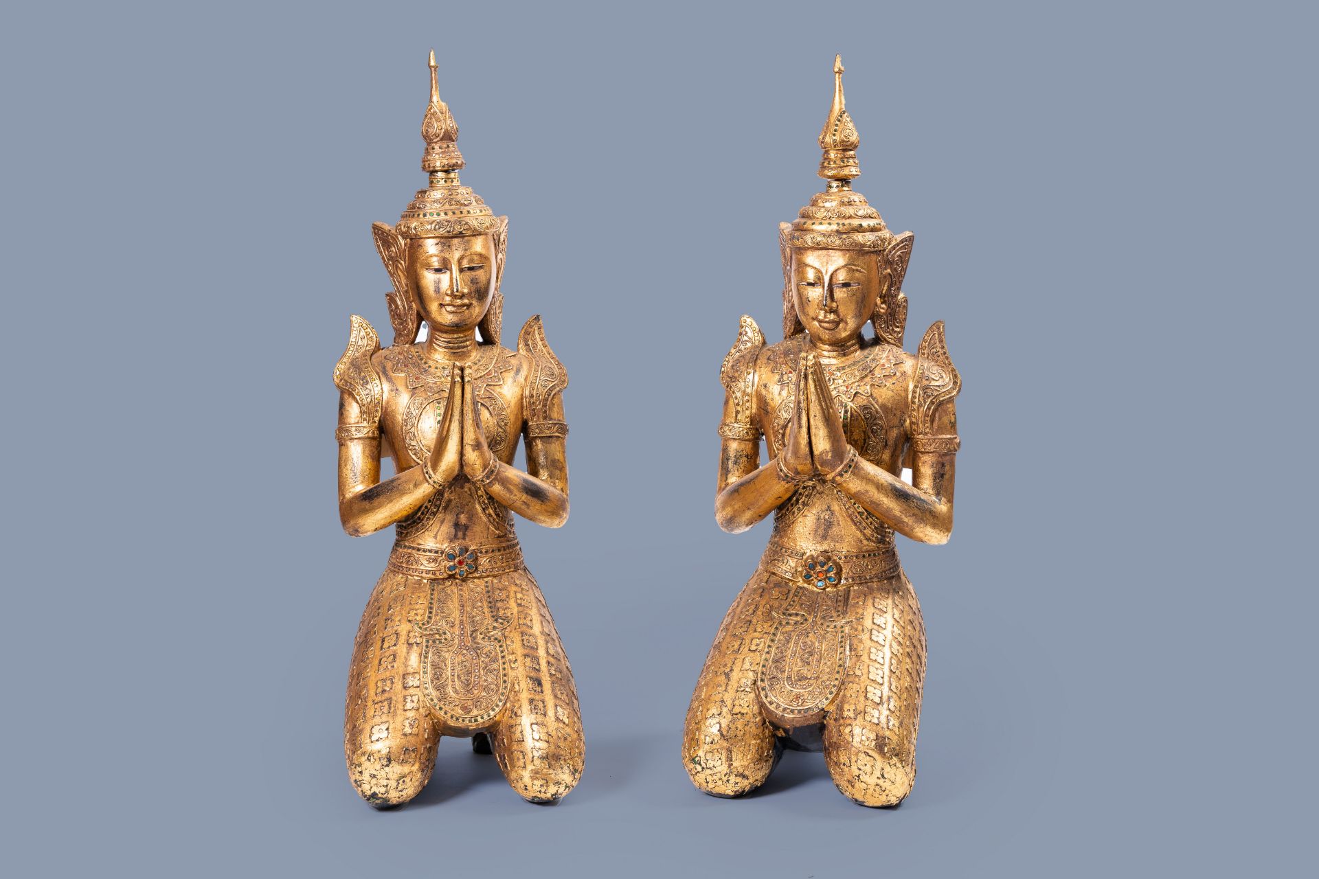 A pair of tall inlaid gilt wood figures of a kneeling Buddha, Thailand, 20th C.