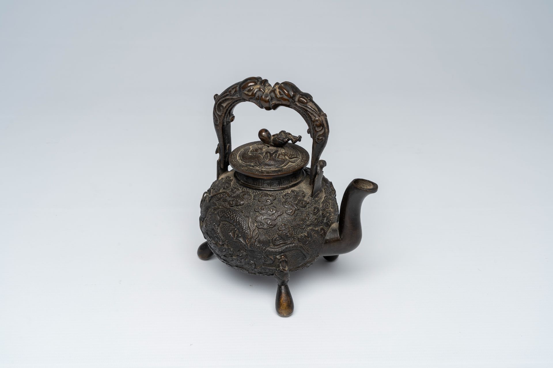 A Chinese tripod bronze teapot and cover with dragon relief design and double gourds, ca. 1900