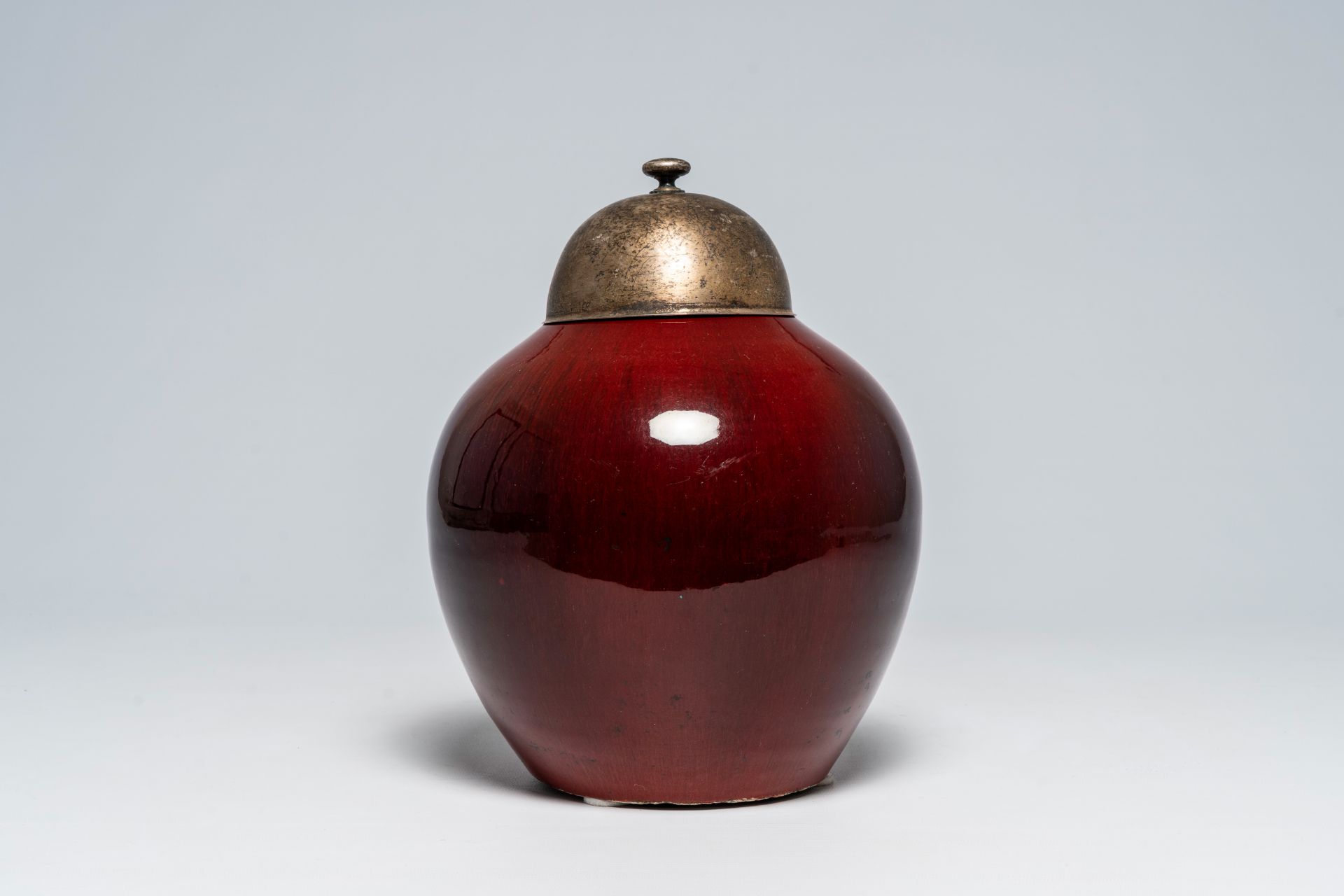A Chinese monochrome flambÃ© glazed jar with metal cover, 19th C.