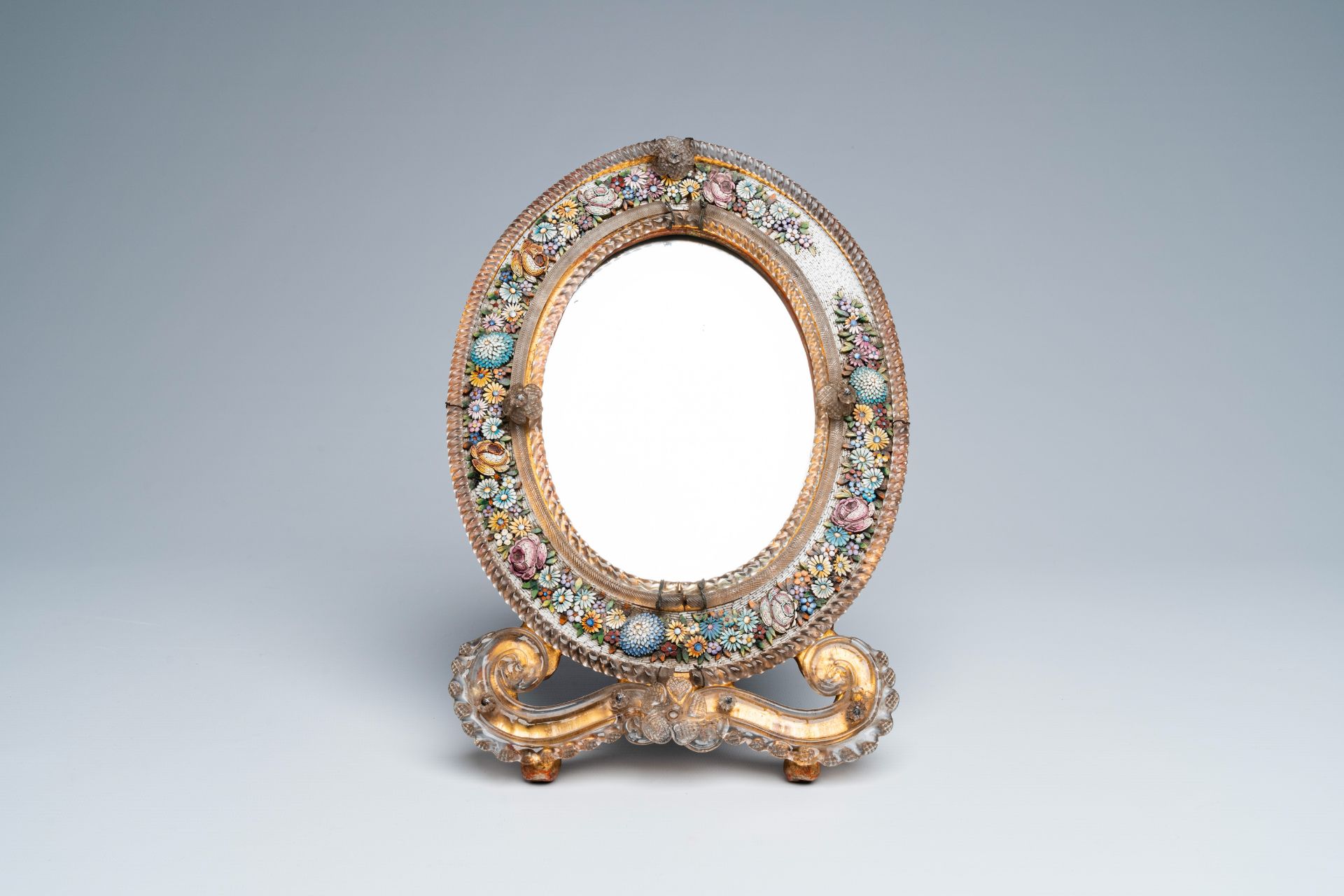 An Italian micro-mosaic table mirror with floral design and glass flowers adorning the top and botto