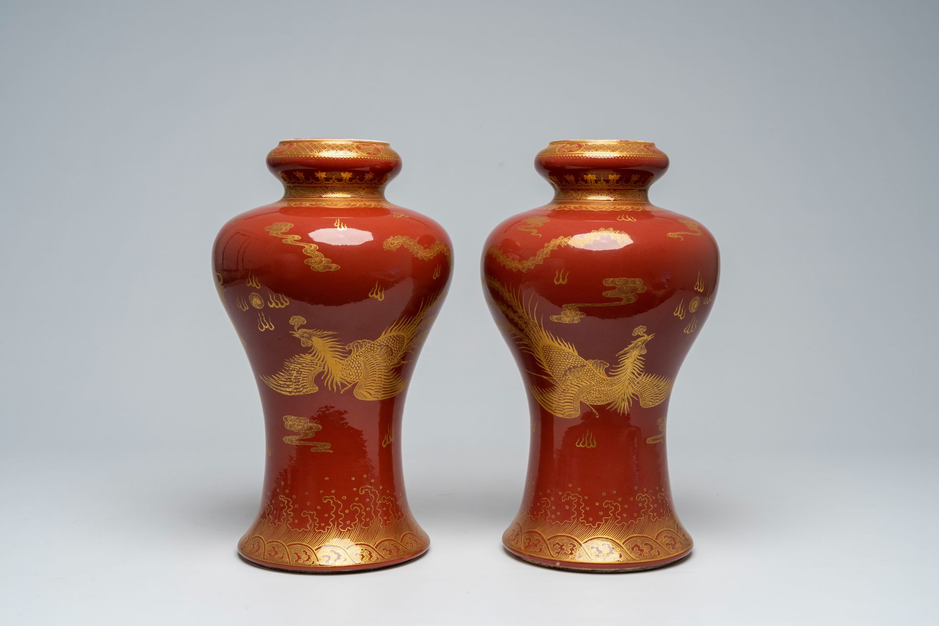 A pair of Chinese monochrome red vases with a gilt 'dragon and phoenix' design, 19th/20th C. - Image 2 of 5