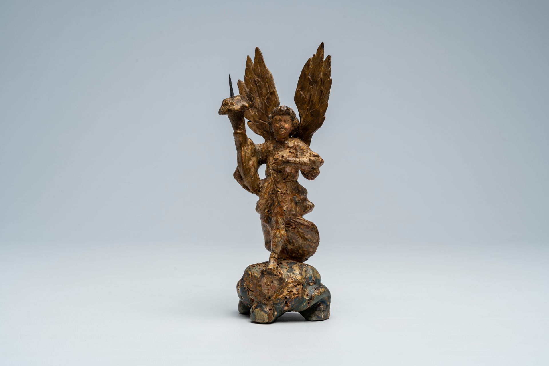An Italian carved, polychrome painted and gilt wood archangel Michael shaped candlestick, 17th C.