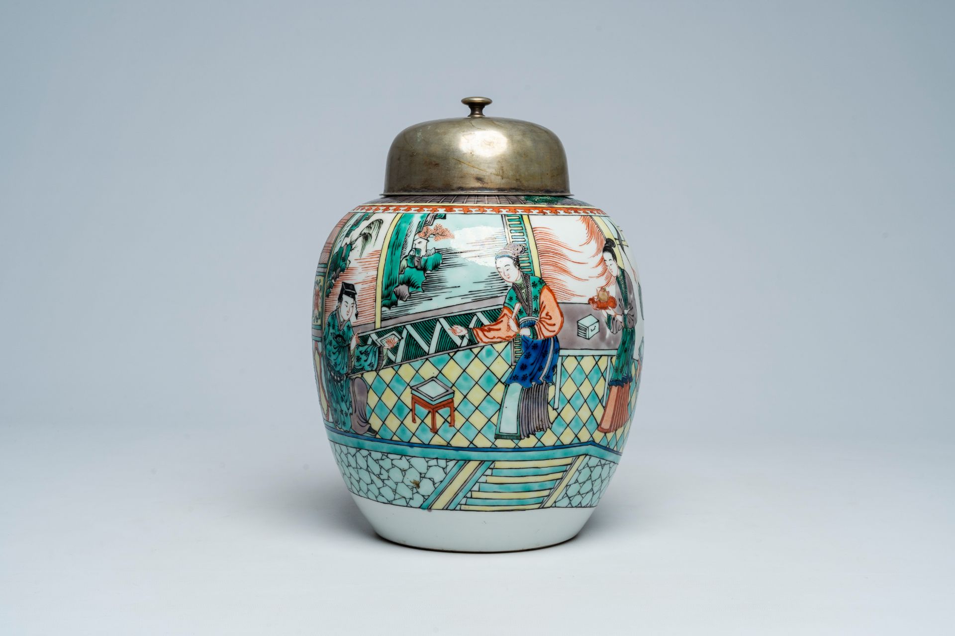 A Chinese famille verte jar with an animated palace scene and a silver-plated cover, 19th C.